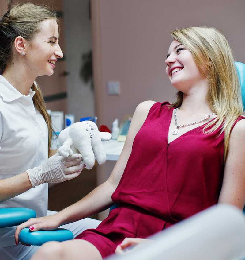 Dentiste et patiente souriantes à la clinique Oralia à Auderghem